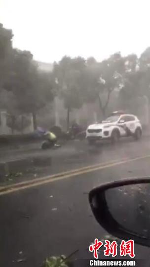 南京一男子大雨天摔倒街头 民警顶风雨为其挡住