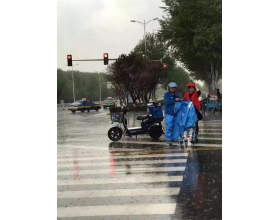 外卖小哥雨中脱下外套 护送婴儿车过马路