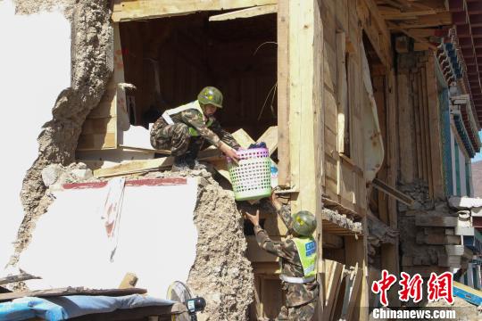 图为驻藏武警某部交通三支队官兵帮助受灾民众转移物资。　杨宁 摄
