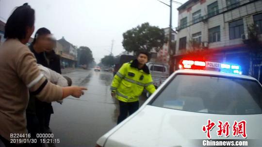 民警将求助妇女及幼儿接上警车 宜昌交警 供图 摄