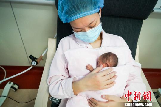 图为重庆市妇幼保健院的新生儿科护士万华正在新生儿科的住院患儿进行“袋鼠式护理”。　向雅诗 摄