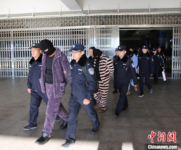 民警押解犯罪嫌疑人走出火车站。　杨文涛 摄