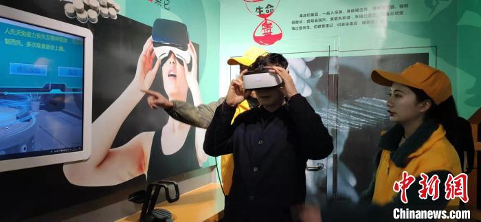 参观者通过VR虚拟现实技术，现场体验吸毒后出现的一些不良反应。　文丽萍 摄