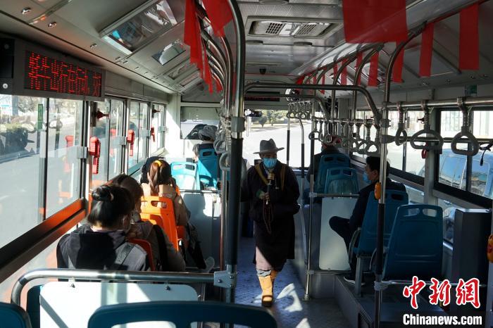 拉萨市民生活如常，图为民众戴口罩乘坐公交车。　江飞波 摄