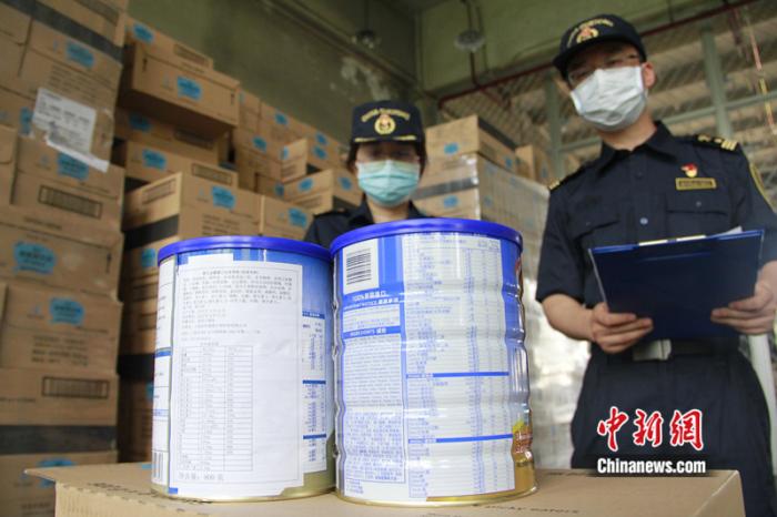 北京海关所属朝阳海关关员正在对“贴牌”与未“贴牌”的同批乳粉进行比对。陈寅松 摄