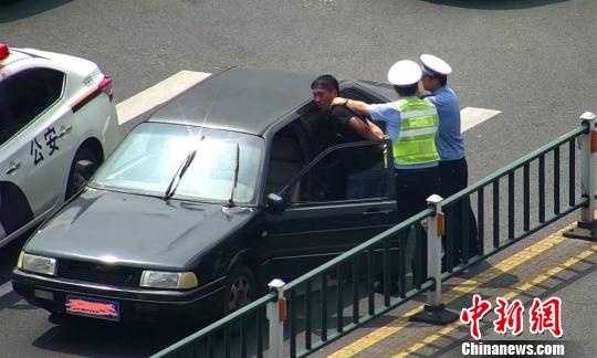 图为常州警方截获套牌车，驾车男子被警方控制。 余人 摄