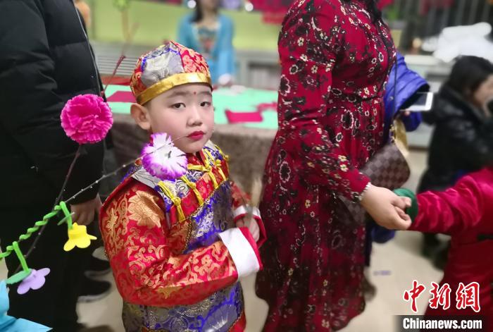 图为兰州幼儿穿着古装，吃着冰糖葫芦，在家长的带领下，买灯笼、学剪纸，感受“中国年”气氛。(资料图) 刘玉桃 摄