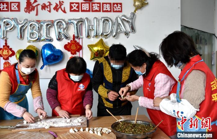 响山社区工作人员与徐新生一起包饺子迎接新春。　朱志庚 摄