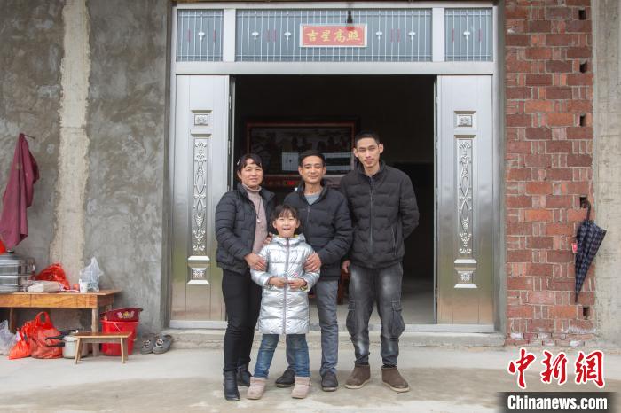 鄱阳县油墩街镇荻溪村，村民黄国平一家在新房面前拍摄了一张全家福。　刘力鑫 摄